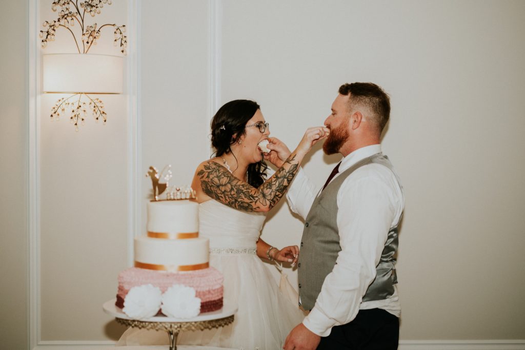Bride and groom feed each other wedding cake
