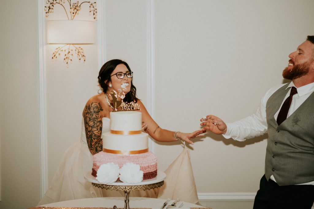 Bride and groom feed each other wedding cake