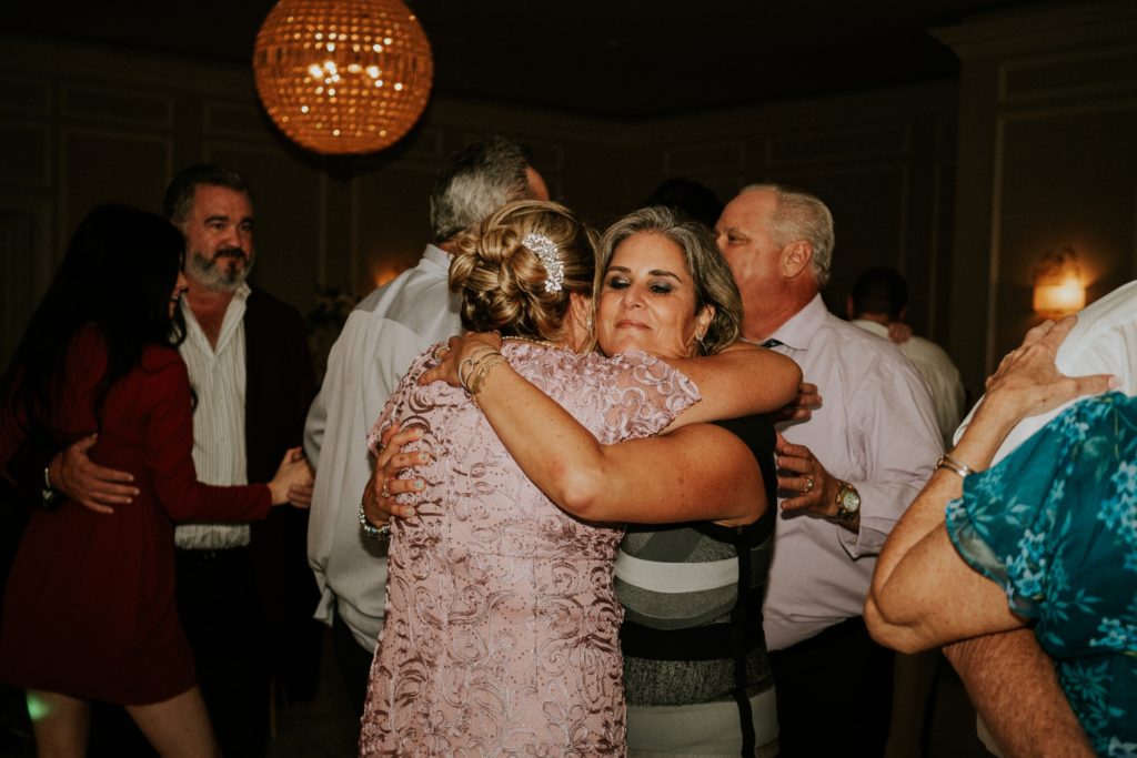 Mom hugs guest at Wanderers Club wedding reception Wellington FL photographer