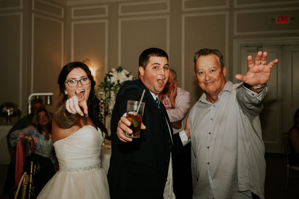 Bride and her dad and brother point at camera at Wanderers Club wedding reception Wellington FL photographer