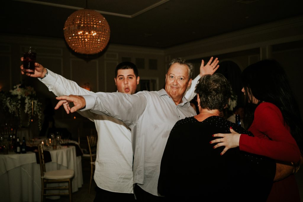 Bride's dad and brother point and dance at Wanderers Club wedding reception Wellington FL photographer