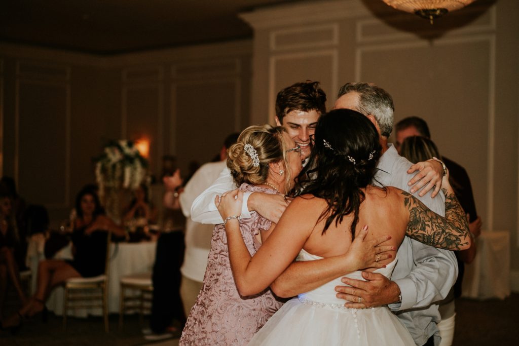 Bride's family hugs at Wanderers Club wedding reception Wellington FL photographer