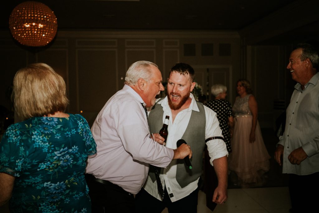 Groom and guest sing with beers at Wanderers Club wedding reception Wellington FL