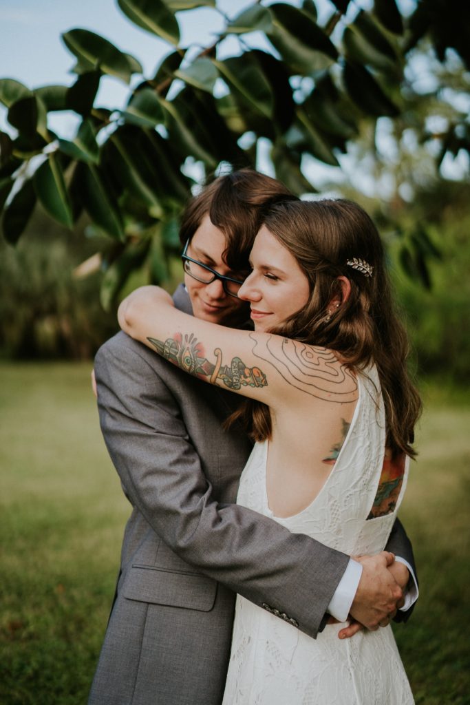 Jupiter Florida backyard wedding elopement groom hugs bride with tattoos