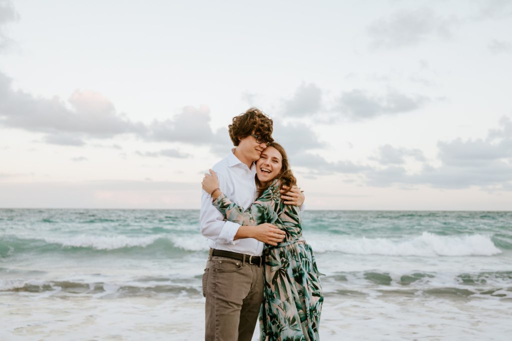 Bri and Aaron hug with ocean in the background at DuBois Park Jupiter beach elopement