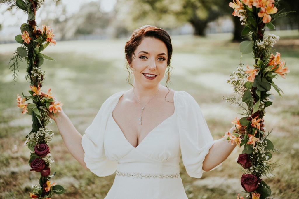 Bride on floral swing wearing vintage wedding dress with puff sleeves