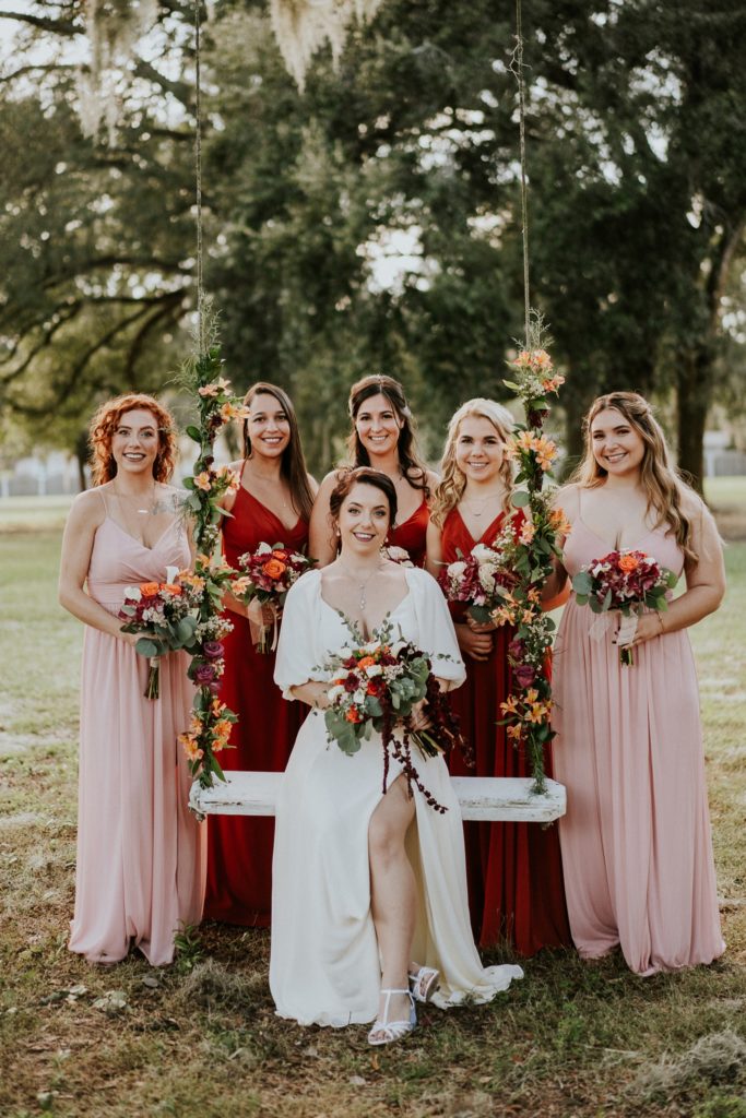 Casa Lantana wedding flower swing with bride and bridesmaids in blush pink and rust orange dresses