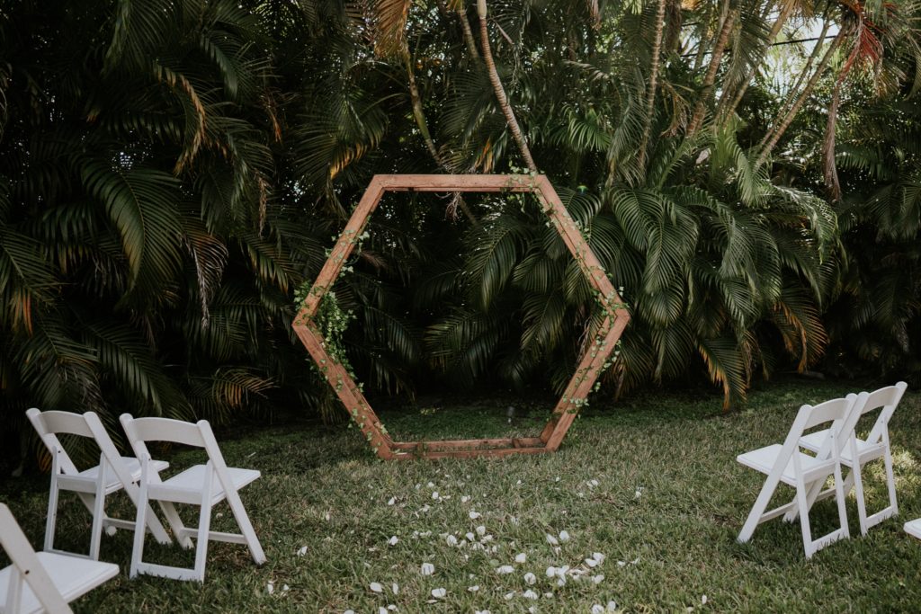 Backyard wedding ceremony with geometric hexagon arch