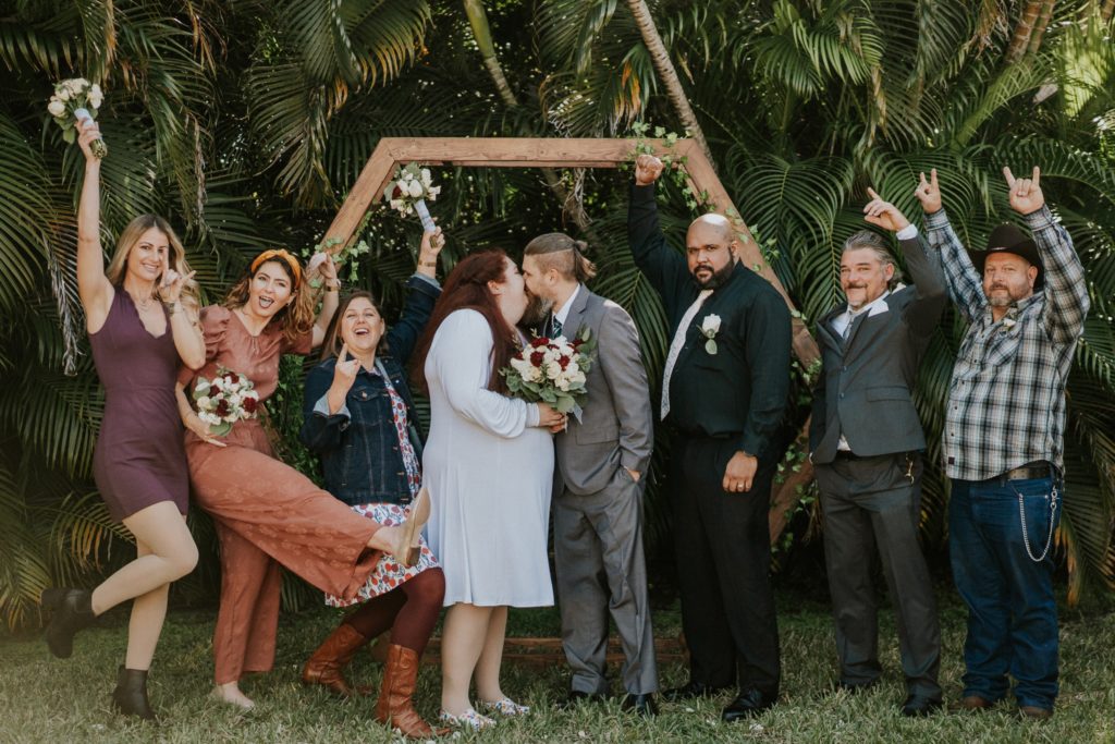 West Palm Beach Florida backyard wedding bridal party cheers as bride and groom kiss