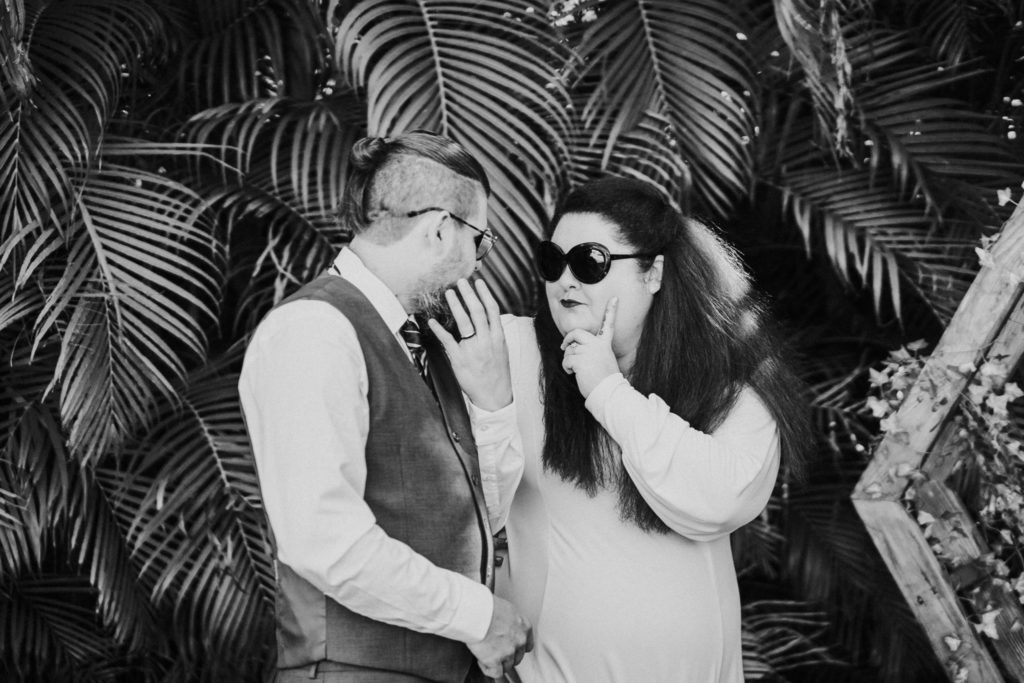 Bride and groom give sassy looks wearing sunglasses in black and white