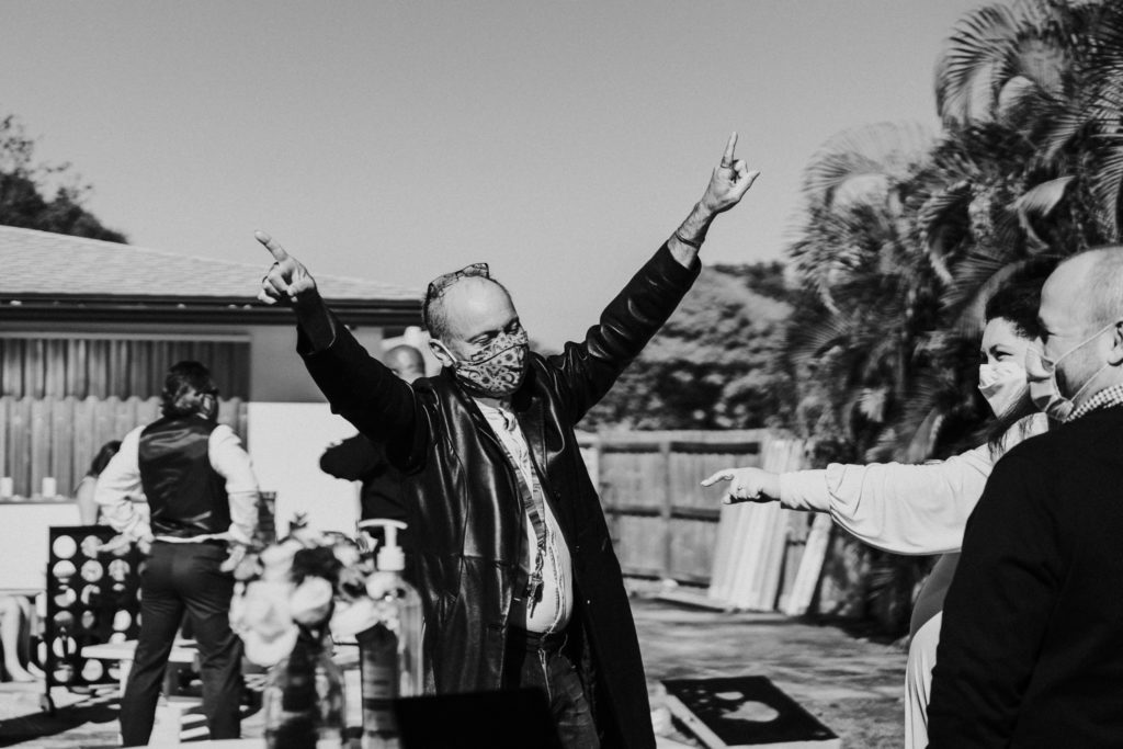 Wedding guests pointing in the air in black and white