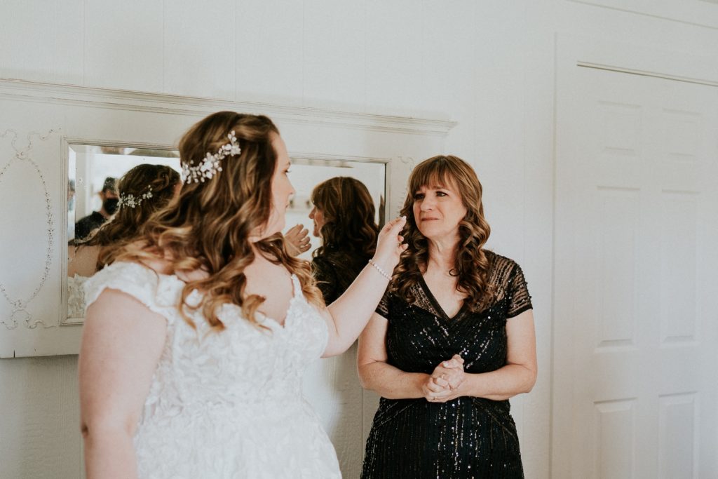 Bride wipes away mom's tear in bridal suite