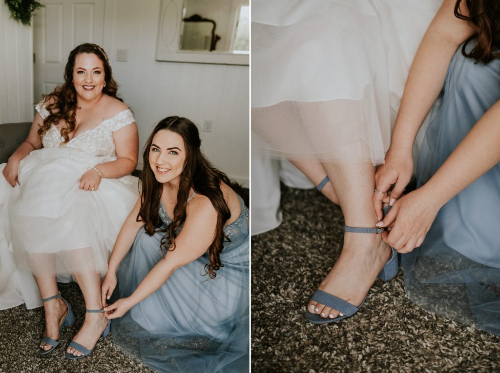 Bridesmaid helps bride put on dusty blue wedding heels