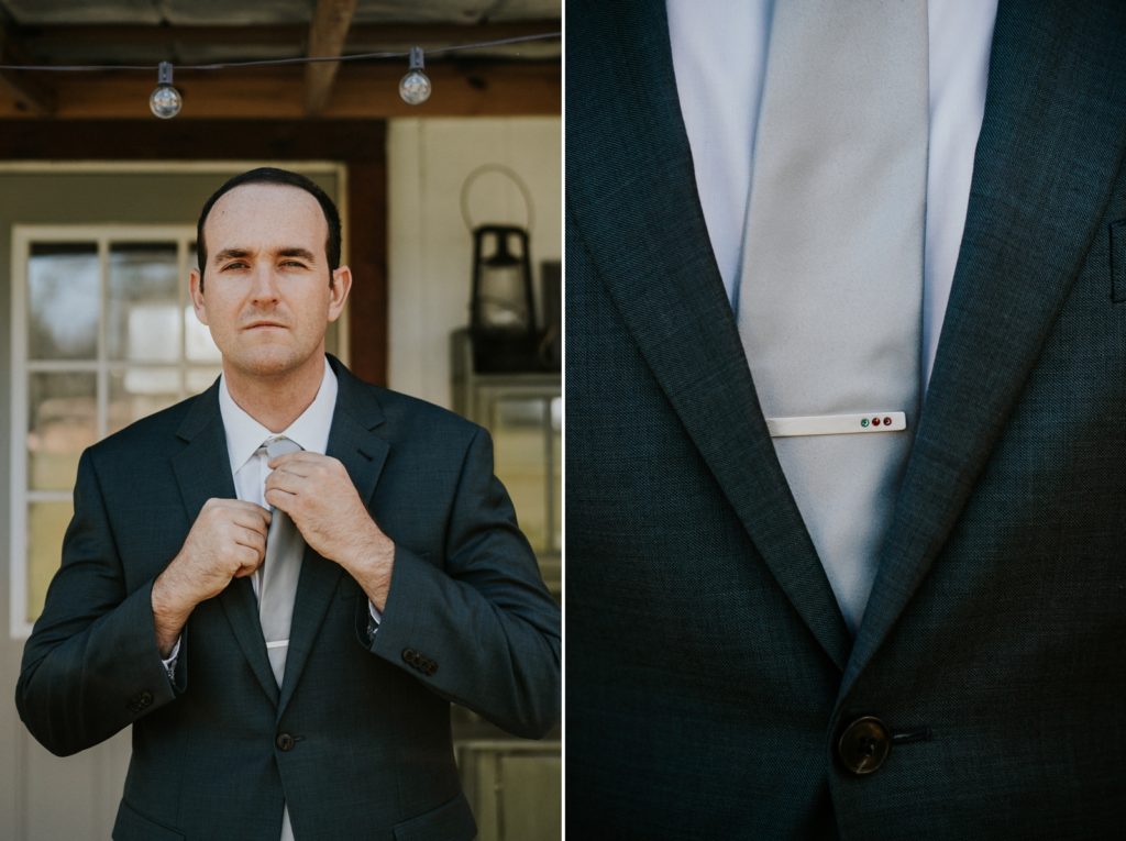 Groom adjusts tie with silver and gemstone tie bar clip