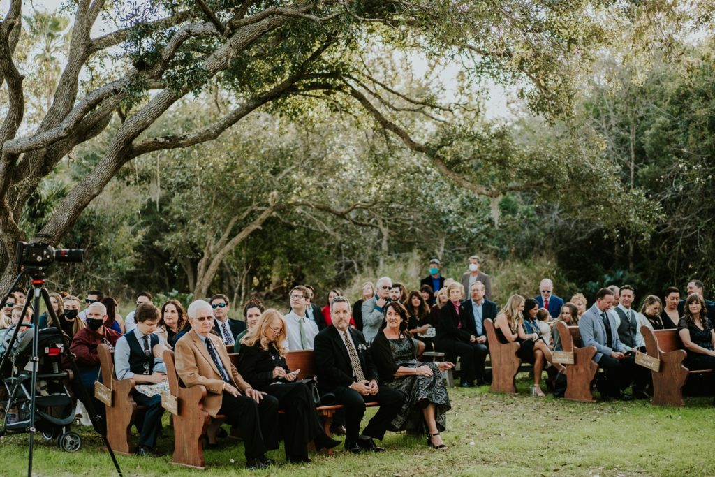 Guests seated under tree for outdoor ceremony FL wedding photography