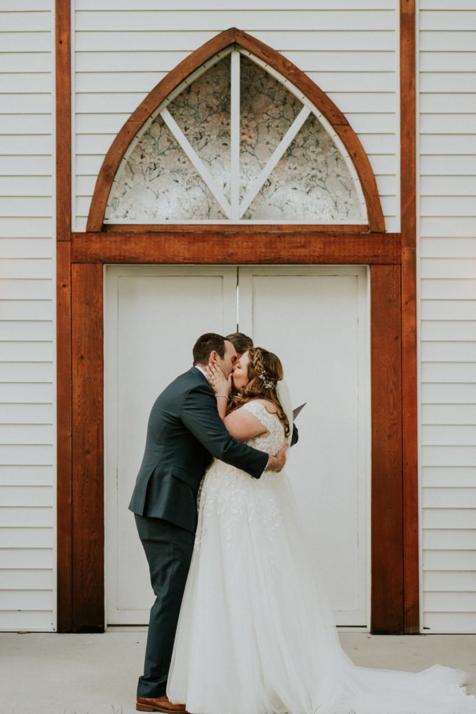 Bride and groom first kiss rustic wedding FL photography