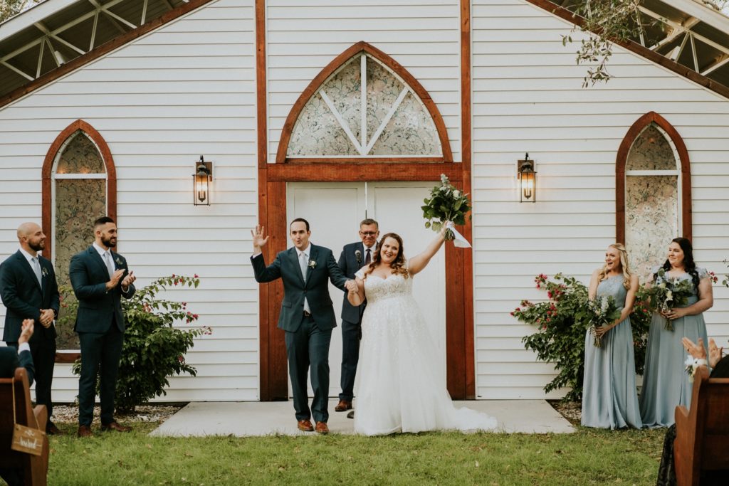Bride and groom cheer after wedding ceremony white FL barn
