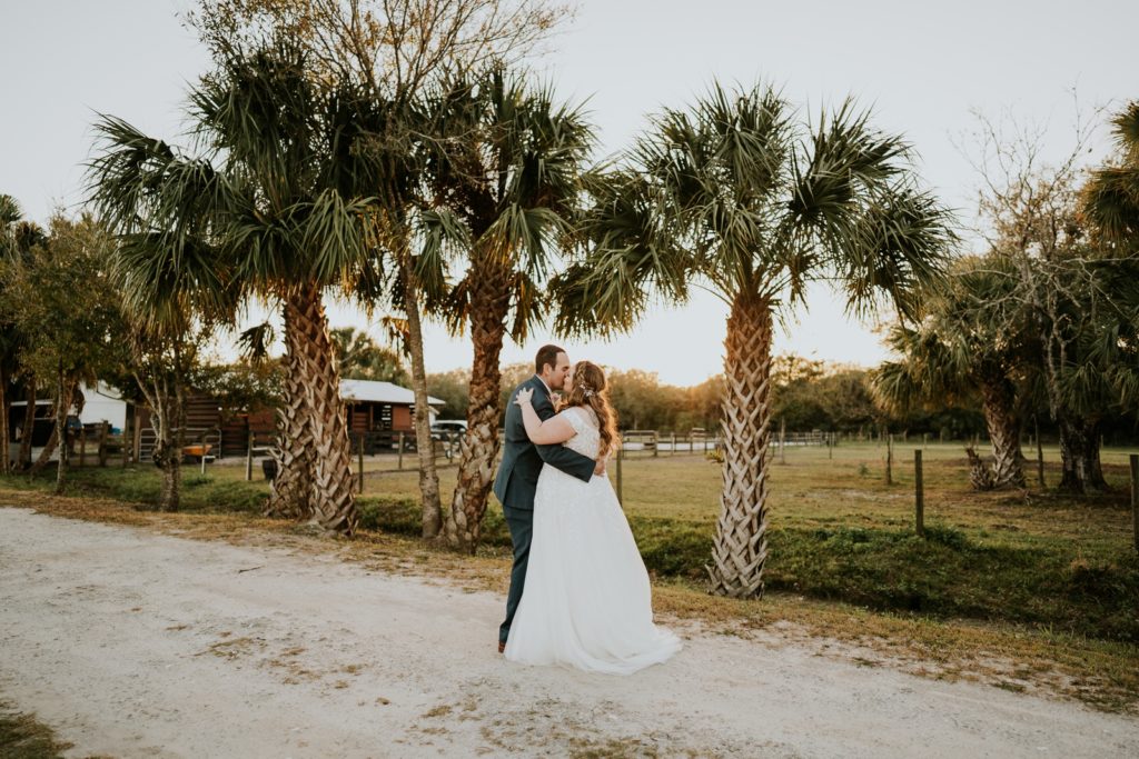 Romantic kiss under palm trees at sunset Stuart Florida wedding photography