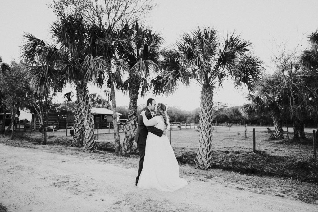 Black and white photo of romantic kiss under palm trees Stuart Florida elopement photography