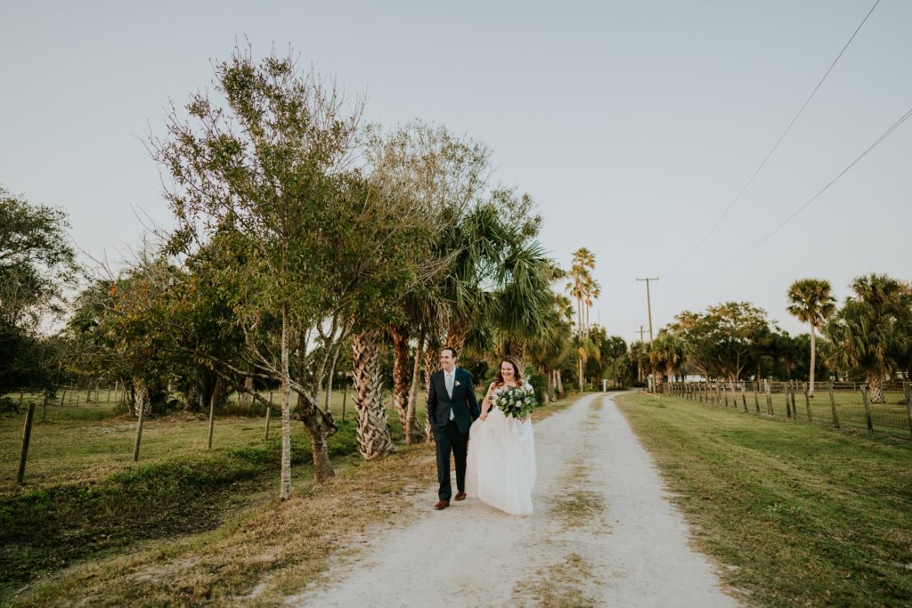Wedding couple walk dirt road at sunset Stuart Florida elopement photography