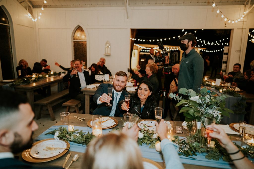 Guests toast at Florida wedding barn dinner reception