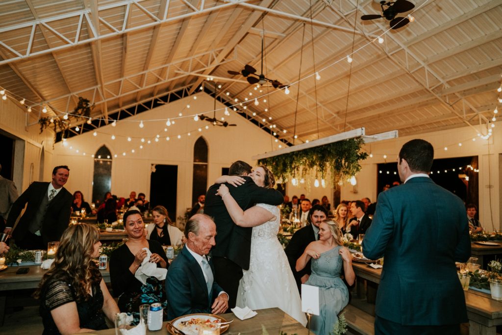 Bride hugs wedding guests in Florida wedding barn reception