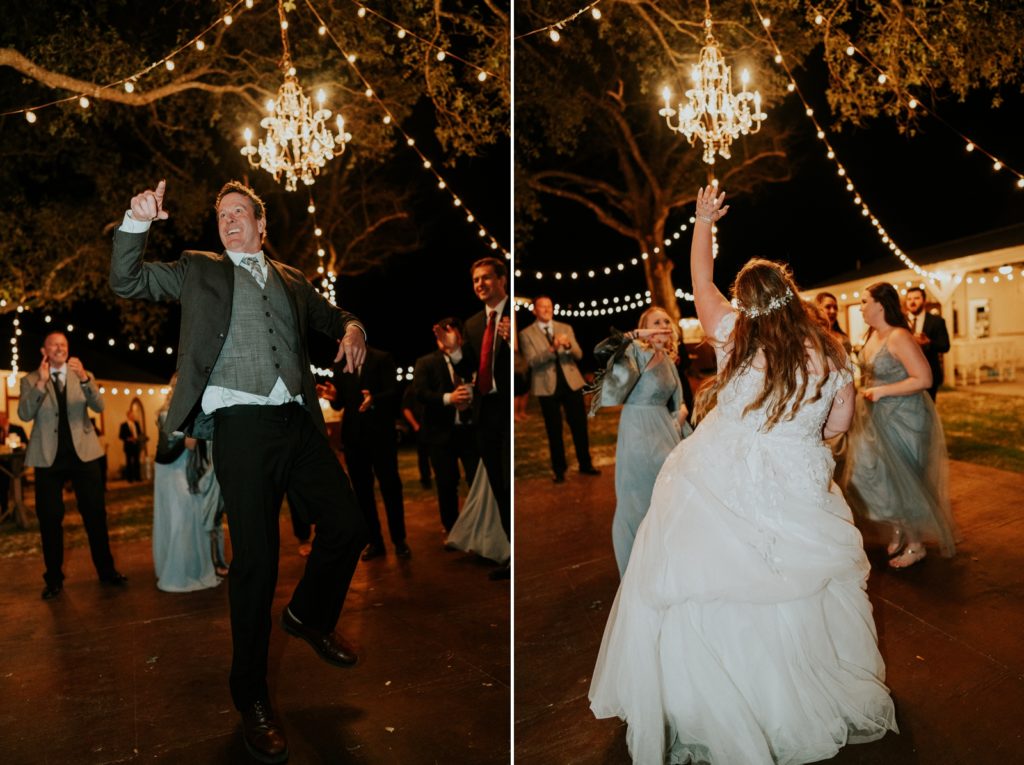Wedding guests dance with bride under chandelier and fairy lights at reception