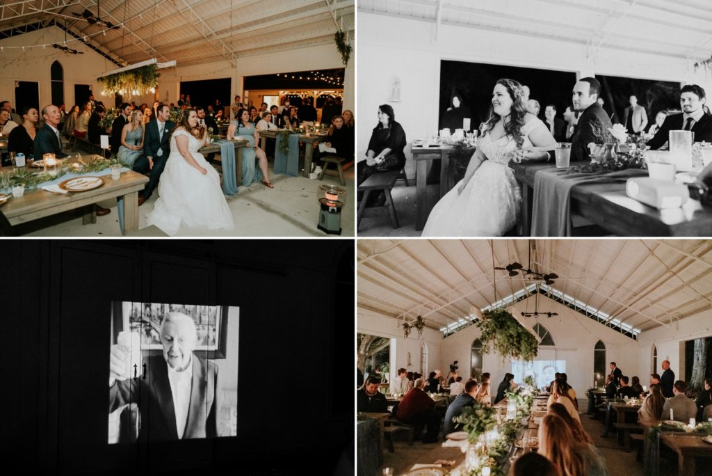Bride and groom watch virtual wedding guest video projected on barn door