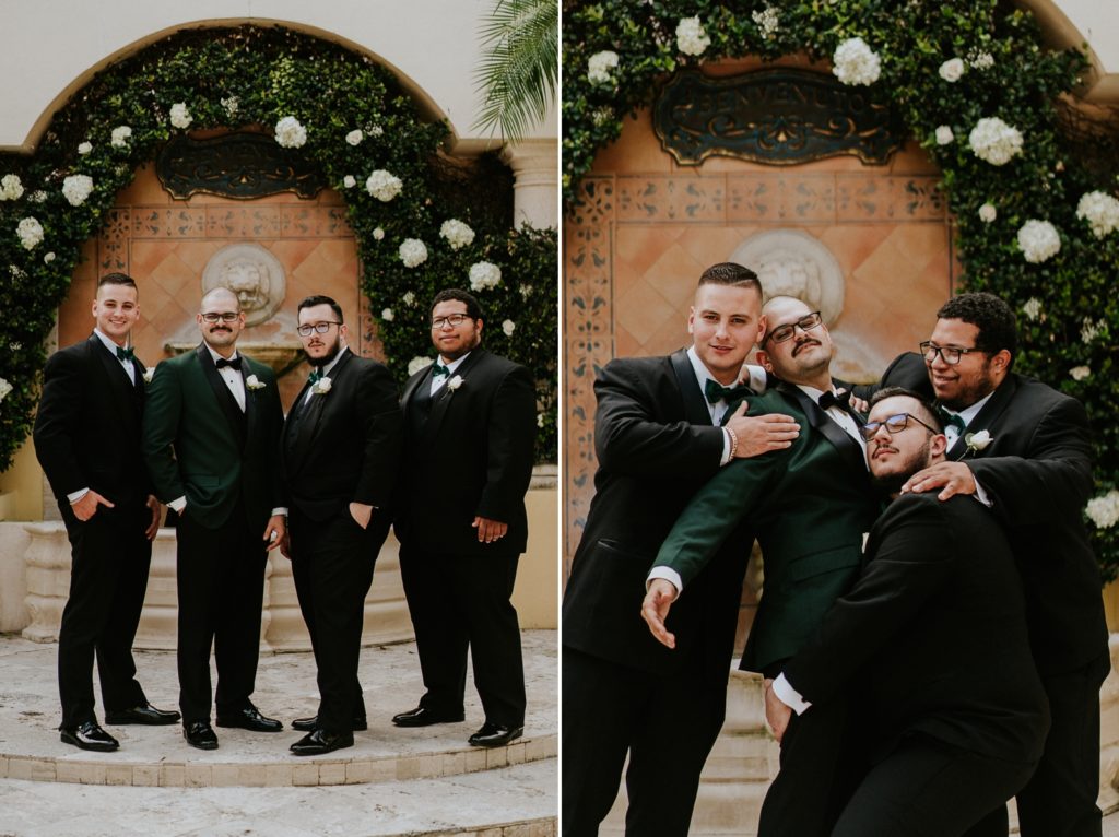 Benvenuto groomsmen in front of white rose greenery wall