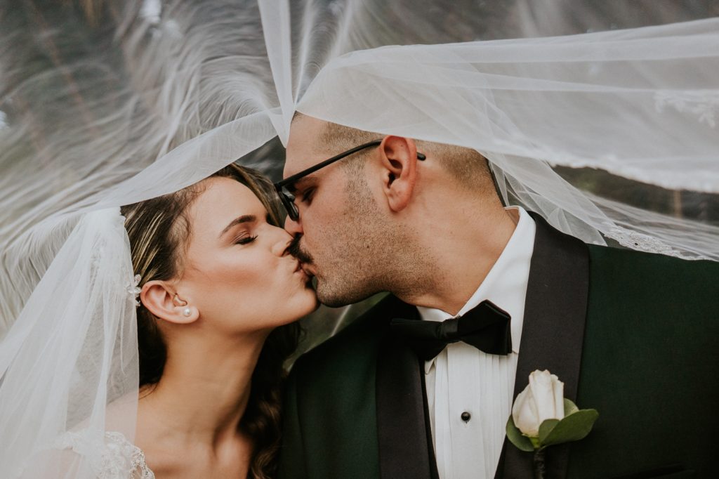 Bride and groom kiss under veil South Florida wedding photography