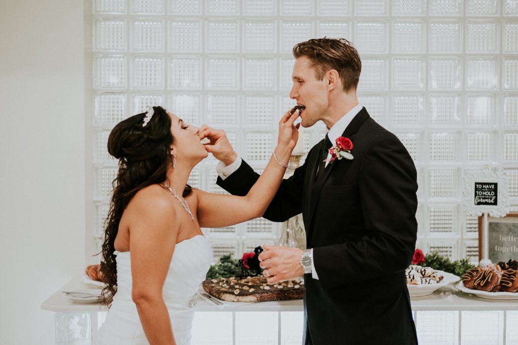 South FL wedding photography bride and groom feed each other vegan cake after cake cutting