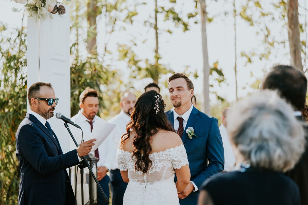 Groom smiles at bride during FL wedding ceremony vows