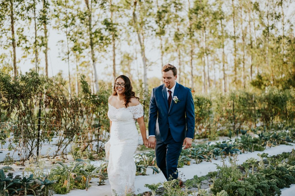 Kai Kai Farm wedding Stuart FL bride and groom walking in greenery