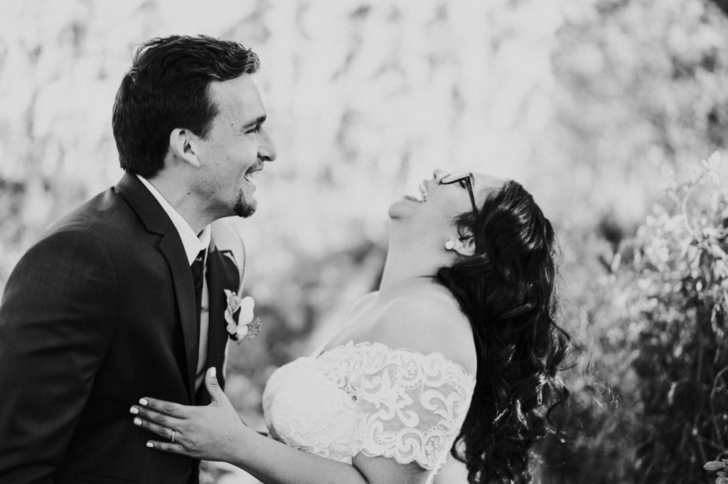 Black and white photo of groom and bride laughing