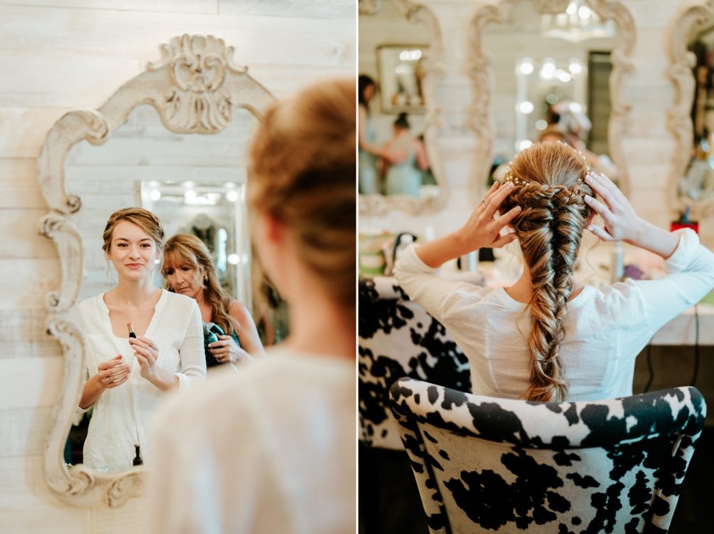 Bride fixing hair and makeup in front of mirror in bridal suite