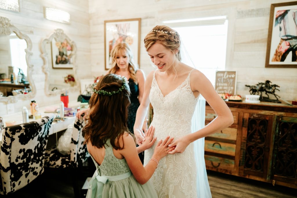 Girl with blindness feels bride's wedding dress in bridal suite