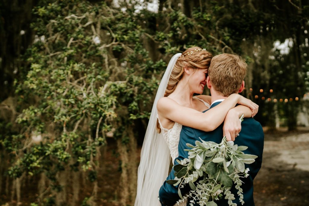 Bride throws arms over groom's shoulders and spins