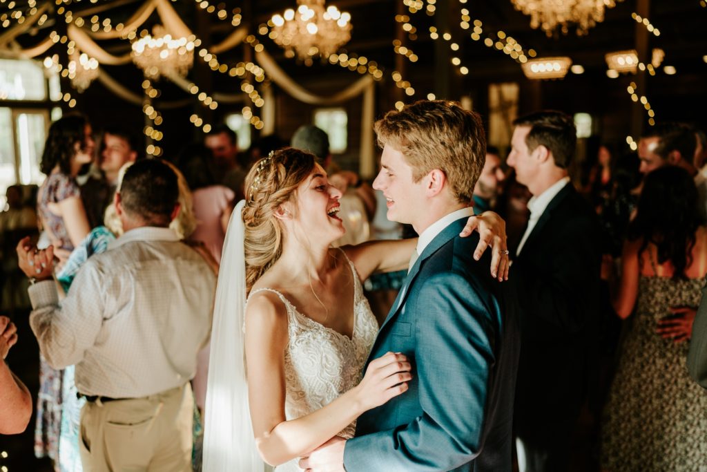 Bride and groom laugh while dancing at Ever After Farms wedding reception