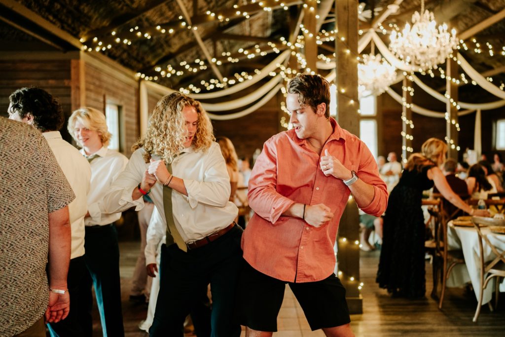 Dancing guests bump hips at wedding reception