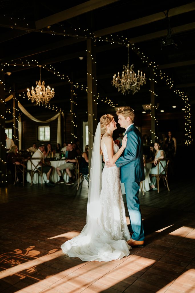 Bride and groom first dance at Ever After Farms Ranch wedding reception dramatic lighting