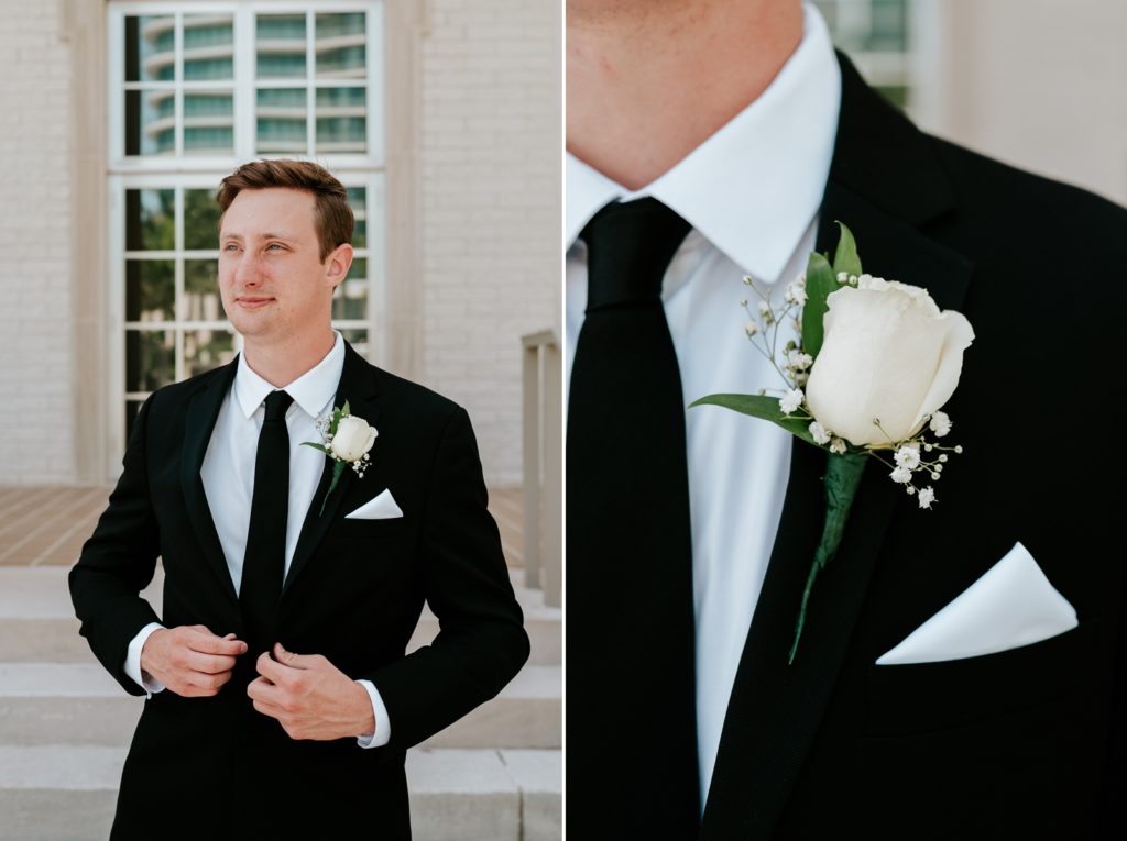 Groom adjusts black suit wearing white rose boutonnière