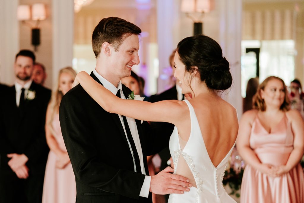 Groom smiles at bride during first dance