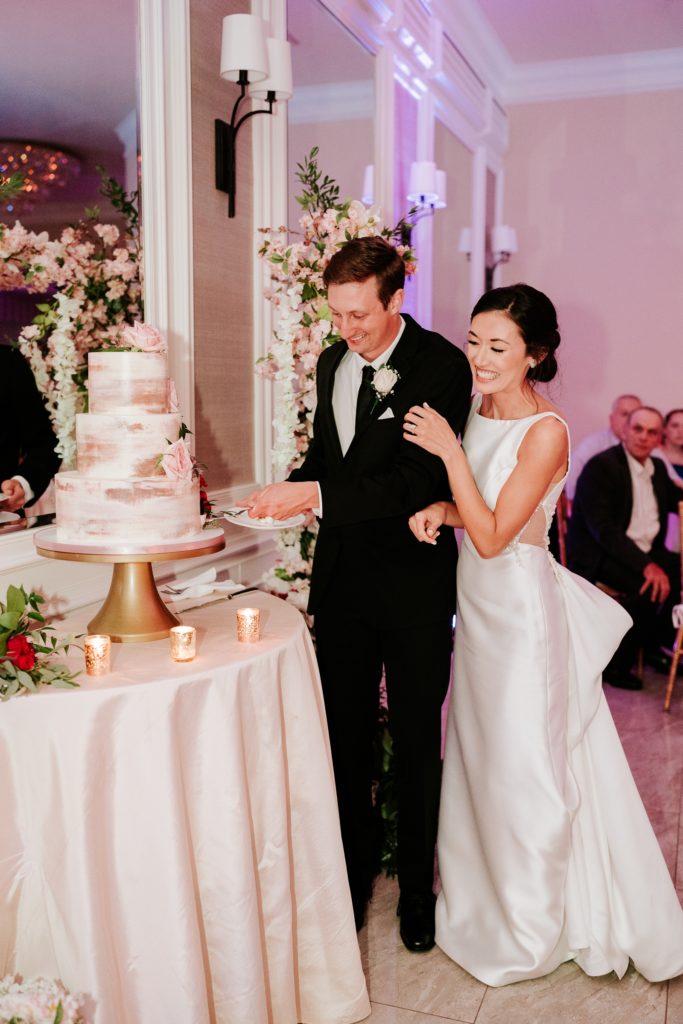 Bride and groom cut cake at Breakers West wedding reception Palm Beach Florida