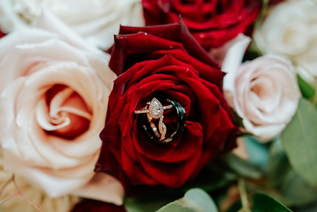 Jared engagement and wedding ring inside red rose bouquet by Infinitely Yours Flowers