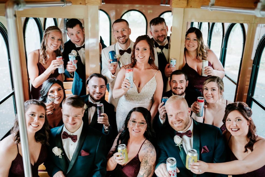 Wedding party hold up drinks inside wedding trolley