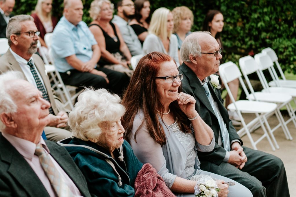 Mother of the groom smiles while watching wedding ceremony