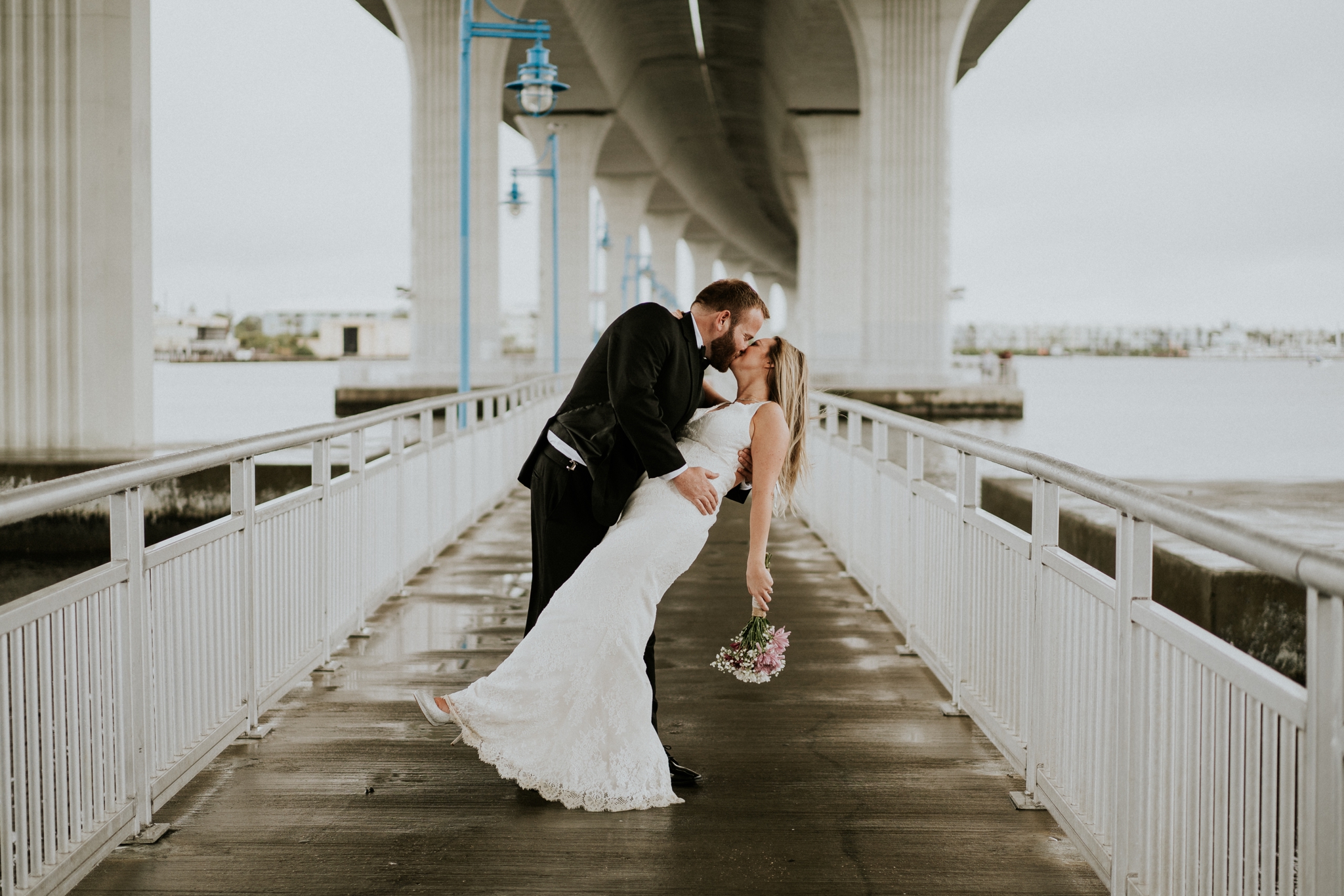 Bride and groom dip kiss under Roosevelt bridge in urban Downtown Stuart FL elopement