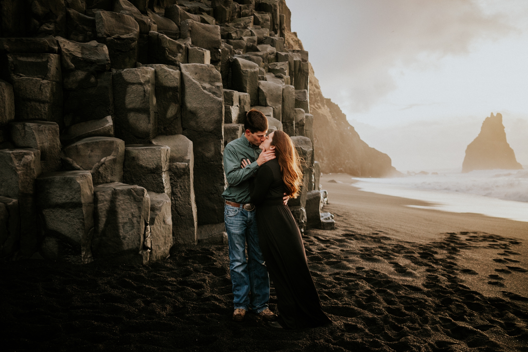 Iceland elopement couple kiss in front of basalt columns at sunrise on Reynisfjara Black Sand Beach Vík