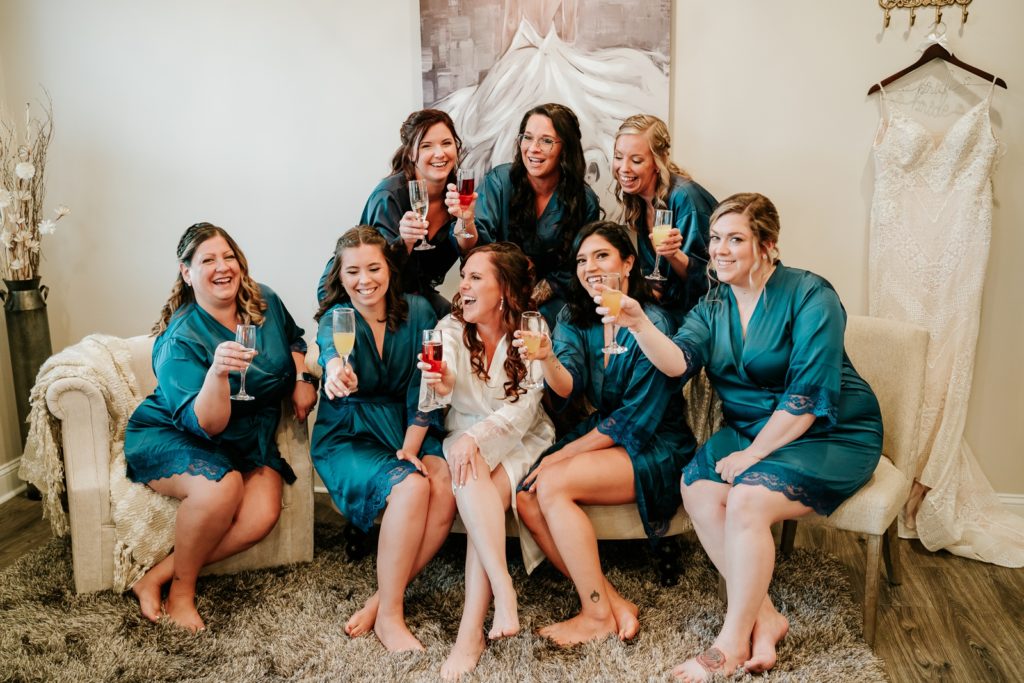 Bridal party toasts champagne glasses in getting ready at Pellegrino's Salon & Suite