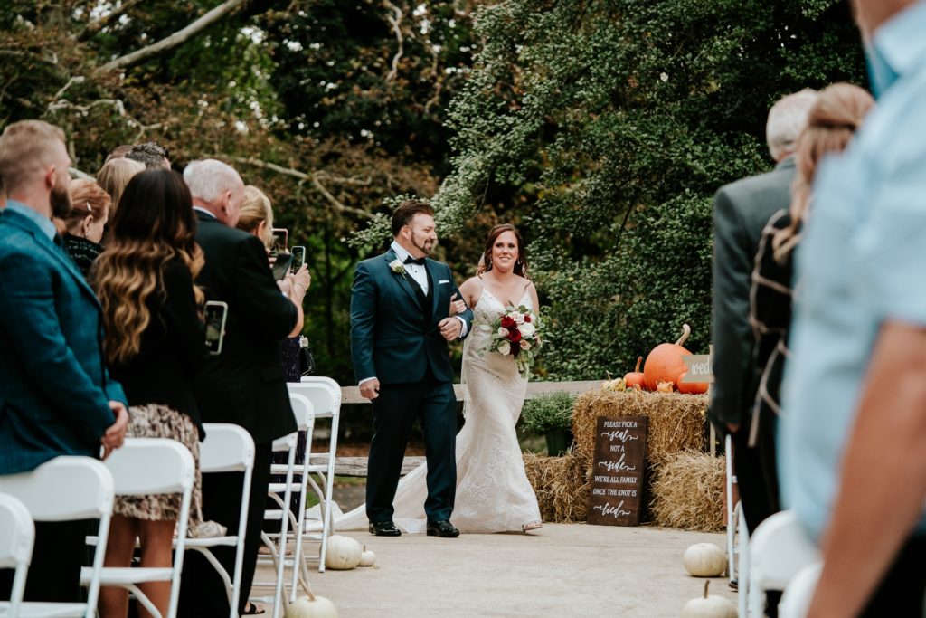 Dad walks bride down the aisle of her fall wedding ceremony